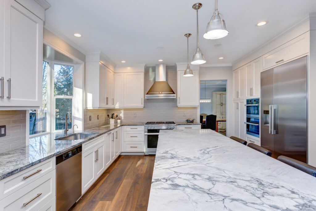 Kitchen with custom white shaker cabinets, endless marble topped kitchen island